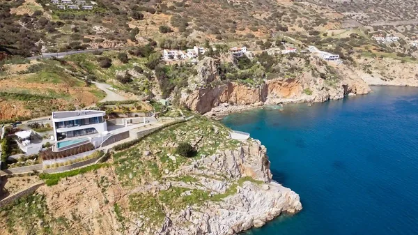 Aerial view of villa on cliff above sea